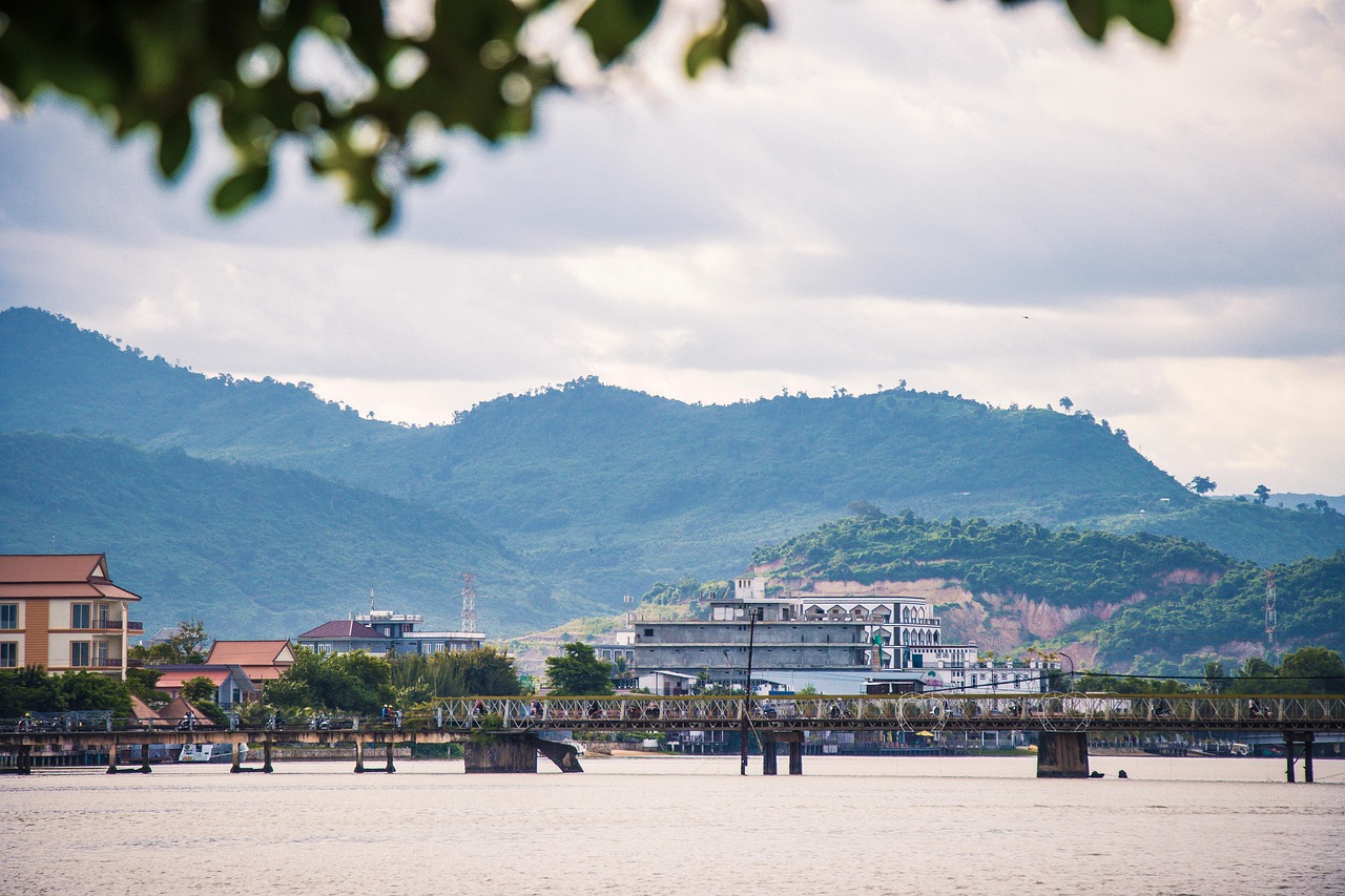 A peaceful sunset view over the Preaek Tuek Chhu river in Kampot with mountains in the background.